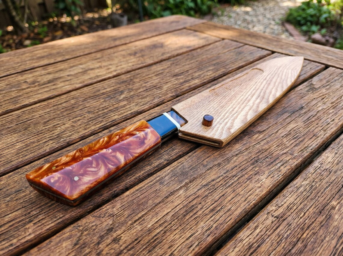 Wooden USB drive with a decorative brown finish on a wooden surface outdoors.